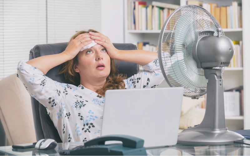 A woman trying to stay cool in her La Porte, TX, home, despite an air conditioner blowing hot air.