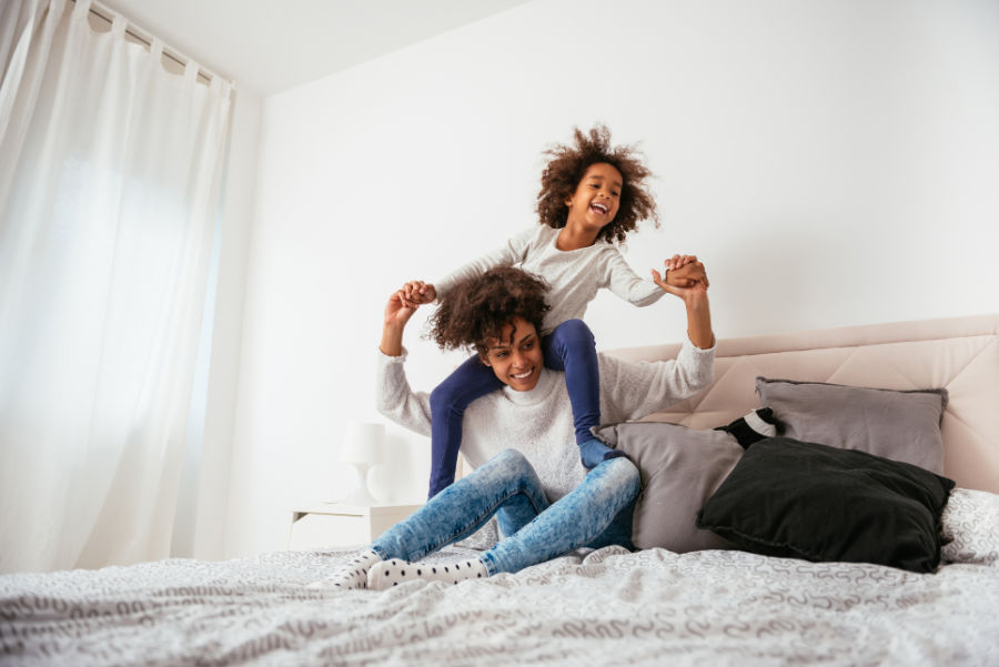 Mom and daughter on the bed in a comfortable home.