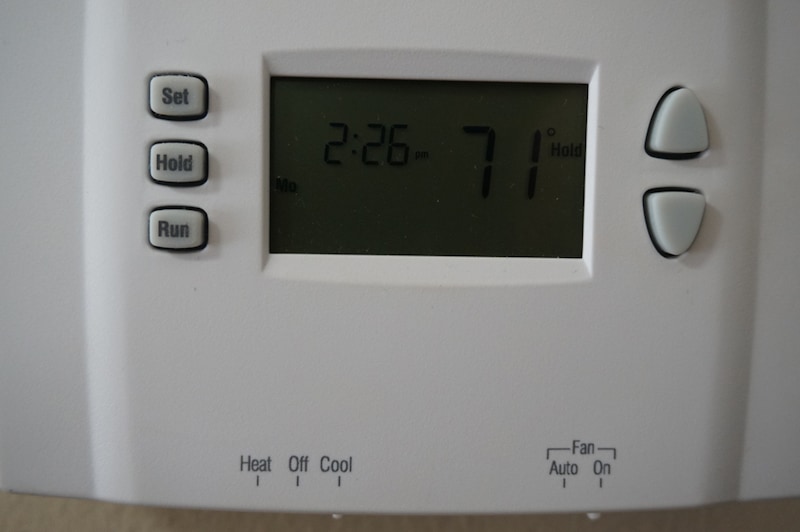 white thermostat hanging on a beige wall