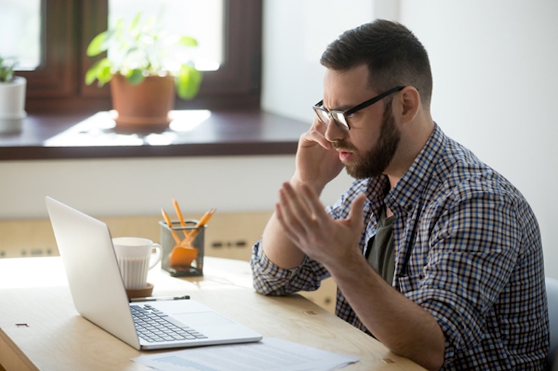 frustrated male employee discussing contract details over the phone