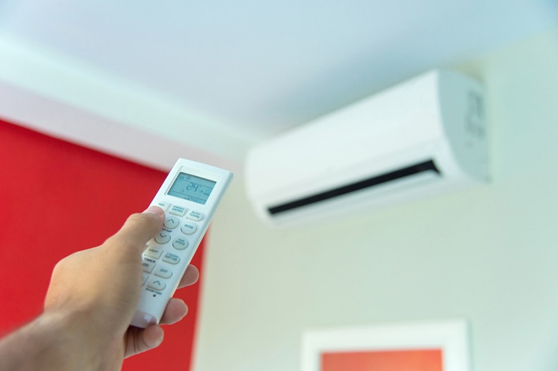 hand pointing a remote at a ductless system