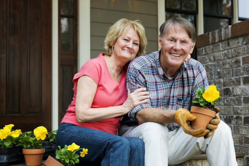 Retired couple sitting on their doorstep after heating and cooling maintenance in Pasadena, TX.