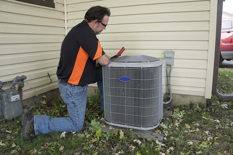 5 Common AC Problems. Repairman checking outside air conditioning unit for voltage.